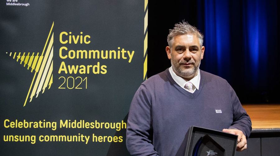 An image of Tony Wedlake holding an award