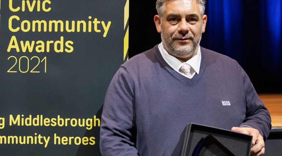 An image of Tony Wedlake holding an award